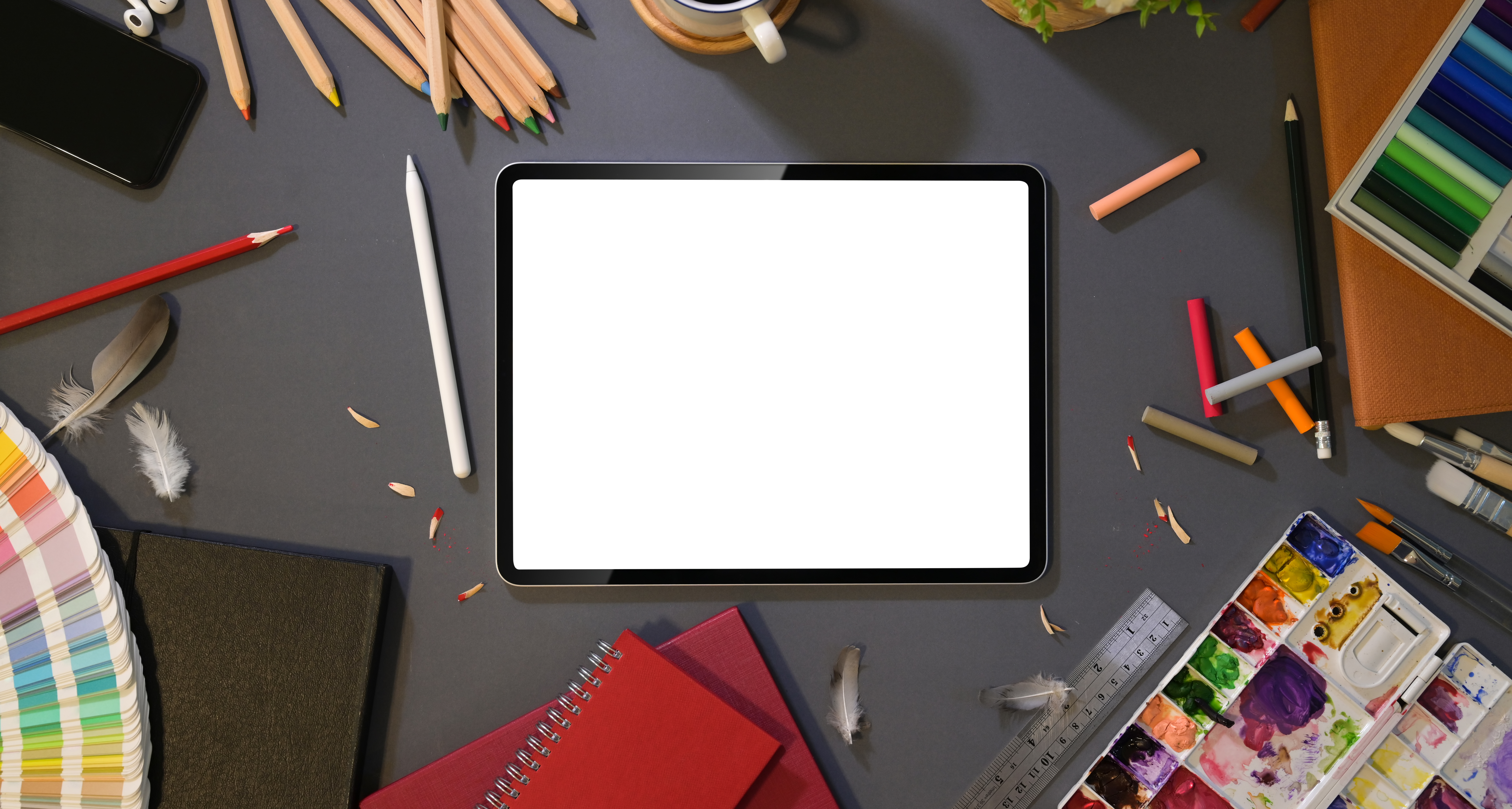 Crayons et peinture autour d'une tablette